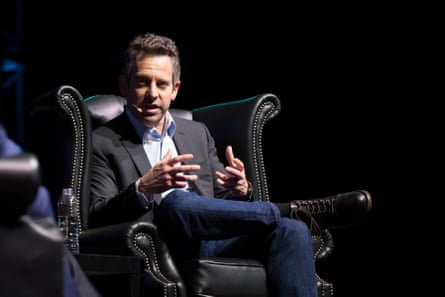 a man speaks while seated onstage