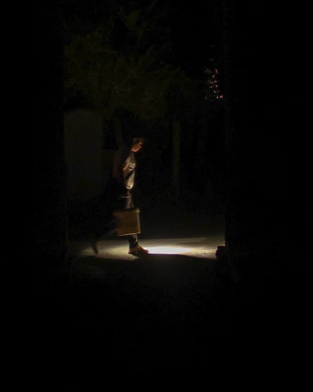 A very dark image, in the centre can barely be seen a solitary figure glimpsed in the glow of a street light during a power cut in the Cuban city of Camaguey.