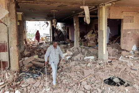 People walk through the rubble of a house hit by an artillery shell in the Azhari district of Khartoum on 6 June 2023.