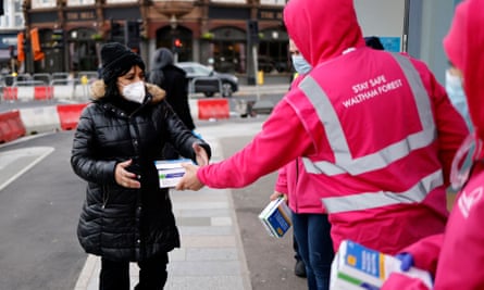 Volunteers hand out boxes of Covid-19 lateral flow tests in north-east London on 3 January 2022.