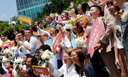 Gay and lesbian newlyweds pose for group photo at a pro same-sex marriage party after registering their marriages in Taipei.