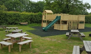 Play area and picnic benches outside the barn and gift shop at Hitchin Lavender, Hertfordshire.