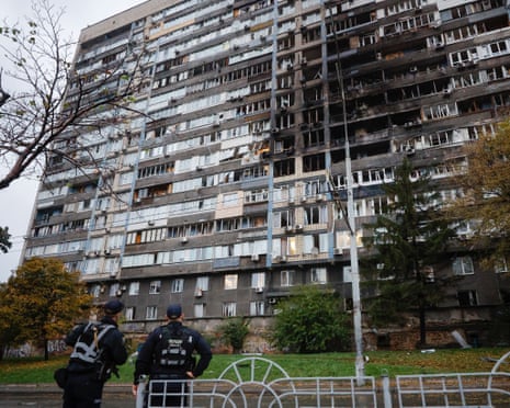 Ukrainian policemen stand near a damaged residential building after a Russian strike in Kyiv, Ukraine, on 10 October 2025.