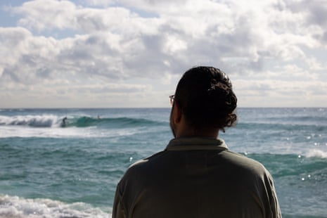 Mostafa Rachwani looks out over waves that crash in from the ocean to the beach