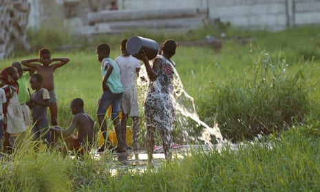 A young girl splashes water on her body at a watering point in Beira, Mozambique