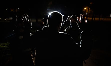 Silhouette of man with hands up facing team