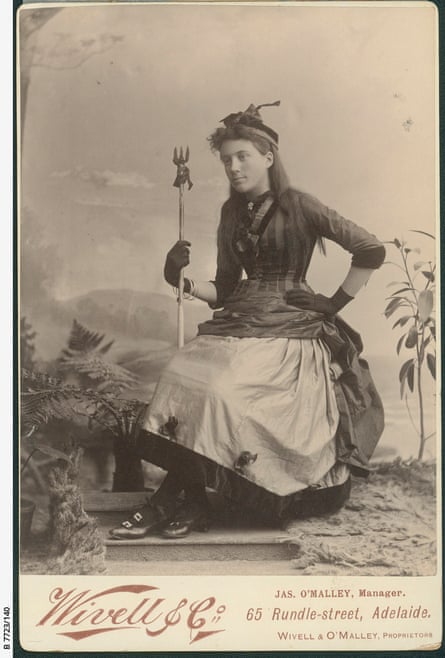 Flossie Greer, 15, in a dark dress and holding a pitchfork