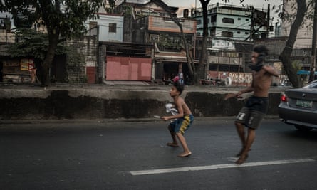 Boys, armed with a knife and a rusty machete, emerge from a slum in Tondo, Manila, to pursue a rival across a highway, through rush-hour traffic to attack him