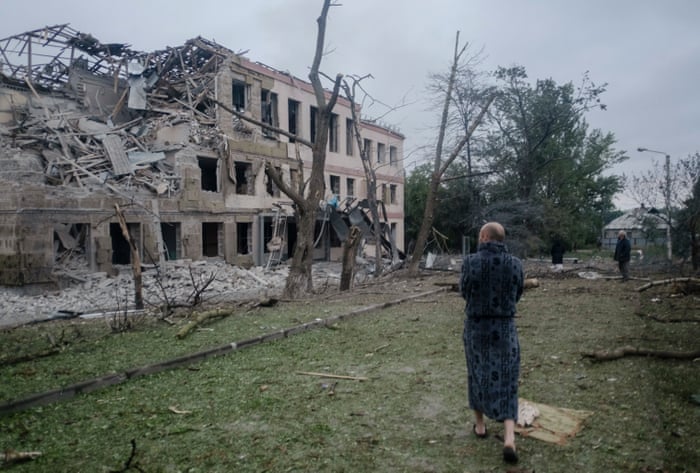 Locals stand in front of a damaged school after a missile strike hit the city of Kramatorsk, Donetsk region, eastern Ukraine, 21 July 2022.