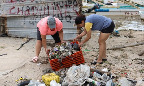 People clean up debris after Hurricane Milton brought heavy rain and flooding to Mexico’s Yucatan peninsula on Tuesday.