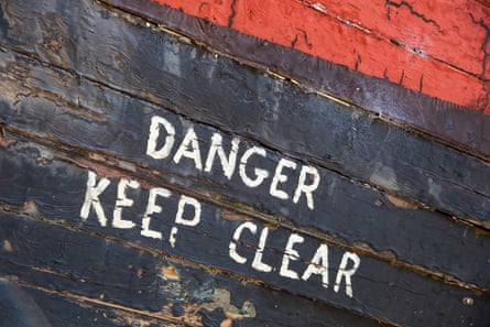 A danger sign painted on to the side of the wreck.