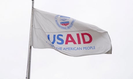 A USAID flag flutters outside, as the USAID building