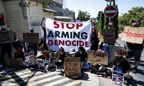 Activists in front of the British consulate in East Jerusalem with large banner reading 'Stop arming genocide'