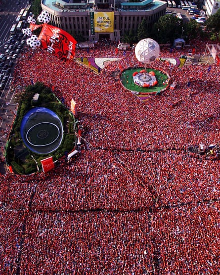 도시 광장에서 빨간색 옷을 입은 수천 명의 사람들을 공중에서 본 모습