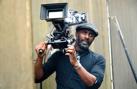Idris Elba holding a camera, directing his film Yardie