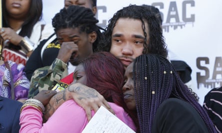 Trayvon Wiseman, center, a cousin of Stephon Clark, hugs Clark’s mother, SeQuette Clark, left, and grandmother, Sequitta Thompson, right, during a news conference in Sacramento.