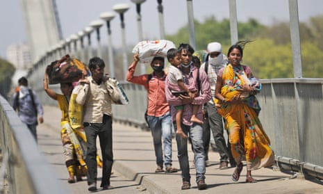 On the outskirts of Allahabad in Uttar Pradesh, Nidhi Patel and her husband, Vikas Patel, centre right, both migrant workers, carry their children as they walk home to their village.