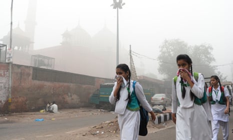 Girls wearing white dresses cover their mouths from the smog