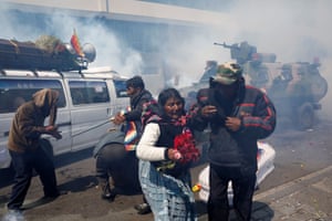 People scatter as tear gas is fired into the crowd.