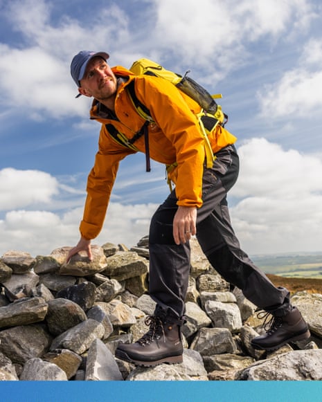 Paddy Maddison uses one hand to balance himself as he hikes over a rocky hill