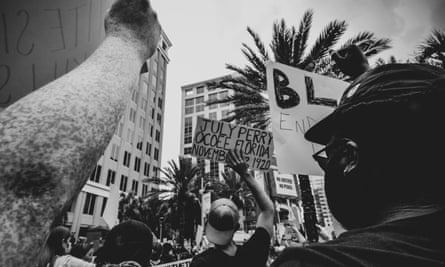 A Black Lives Matter protestor holds up a sign for July Perry who was lynched 100 years ago in the Ocoee Massacre in Ocoee, Florida.