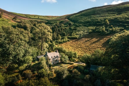 A cottage nestled among green hillsides in Wales