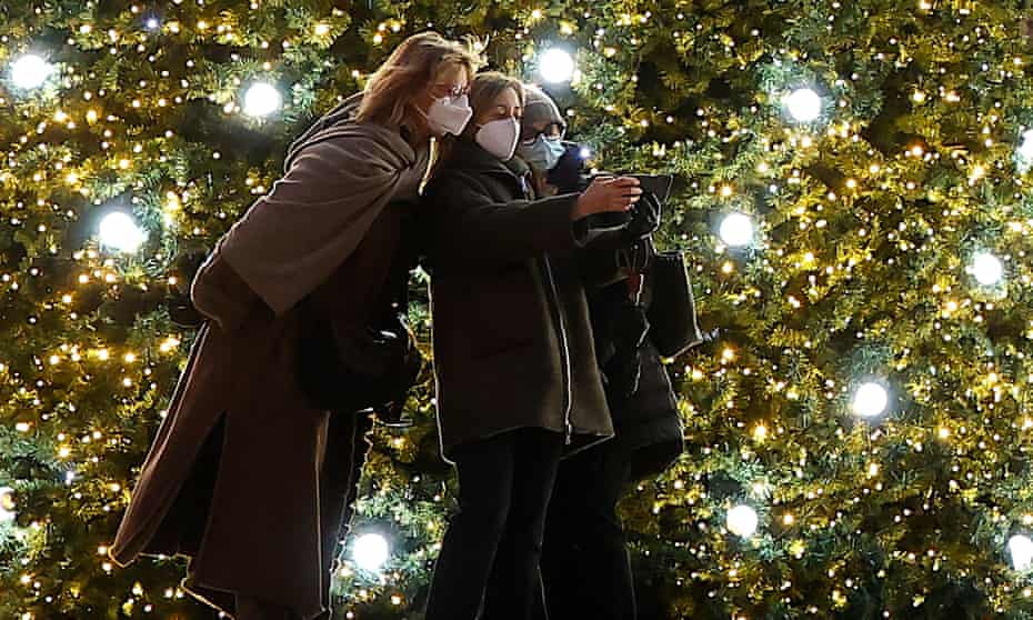 Masked people in Paris by Christmas trees