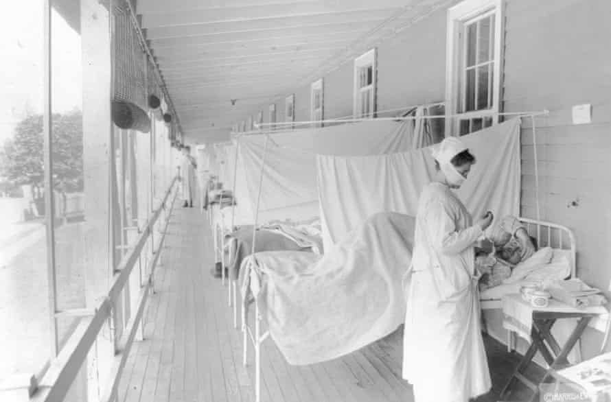 Seorang perawat merawat seorang pasien di bangsal influenza Rumah Sakit Walter Reed, Washington, 1918.