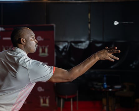 Peter Wachiuri throws a dart.