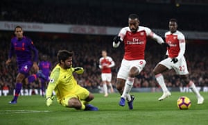 Alexandre Lacazette evade a Alisson antes de subir de nivel para el Arsenal en la visita del Liverpool a los Emiratos la temporada pasada