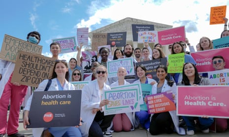 Doctors and other medical professionals hold placards in support of abortion rights