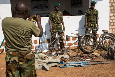 Two rangers pose for a photo next to machetes, knives, spades and other equipment which have been confiscated from poachers and laid out at Chinko’s HQ.