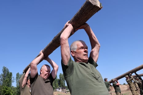 Service personnel hold a log during the training session.