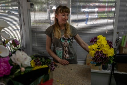 A flower saleswoman in Irpin sells flowers for a funeral in the city, some months after it was liberated from Russian occupation.