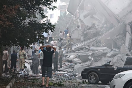 People look over damage to buildings in Tehran after Israeli airstrikes.
