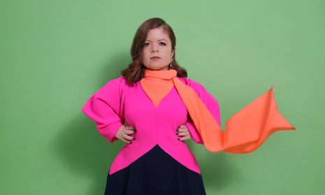 Portrait of Sinéad Burke wearing pink top with hands on hips