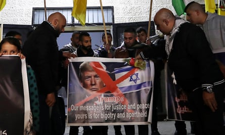 Palestinian protesters hold up a picture of Donald Trump