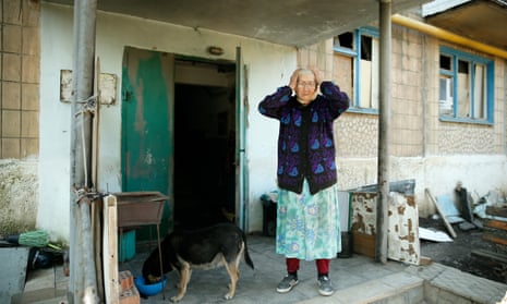 Natalia, 90, stands at the entrance to her apartment block in Vuhledar.