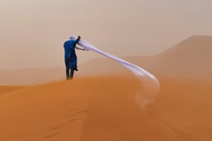 A guide in the Sahara Desert endures a sand storm