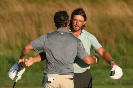 Rory McIlroy and Tommy Fleetwood of embrace on the 18th green after finishing their round.