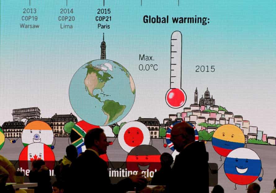 Visitors chat in front of a giant screen featuring information related to global warning