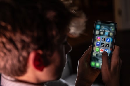 A teenage boy looks at an iPhone screen