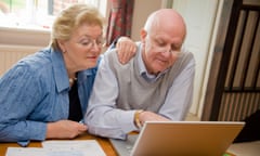Older couple looking at a laptop together while discussing finances