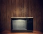 Retro Television in Wood Paneled Living RoomStatic plays on the screen of an old 1980's TV complete with signal antennae, sitting on a table in a domestic room with wood paneling on the walls. Horizontal with copy space.