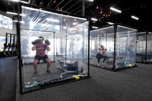 People exercise behind plastic sheets in their workout pods in Redondo Beach, California