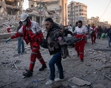 Picture obtained from Iran’s ISNA news agency showing rescue workers carry the body of a victim after a strike on a building in Tehran’s Enghelab Square
