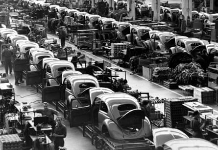 Black and white photo of assembly line of VW Beetles