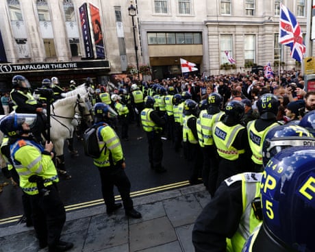 Police confront far-right marchers in a street in London Police confront far-right marchers in a street in London