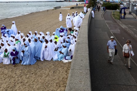 People walk near the seafront as members worship