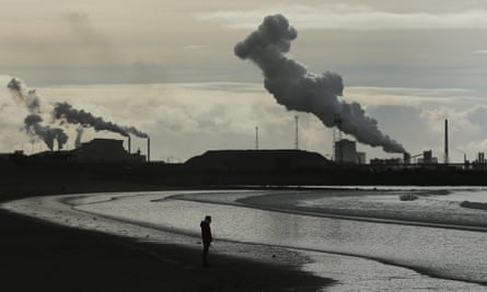 view of Port Talbot smokestacks over lonely beach